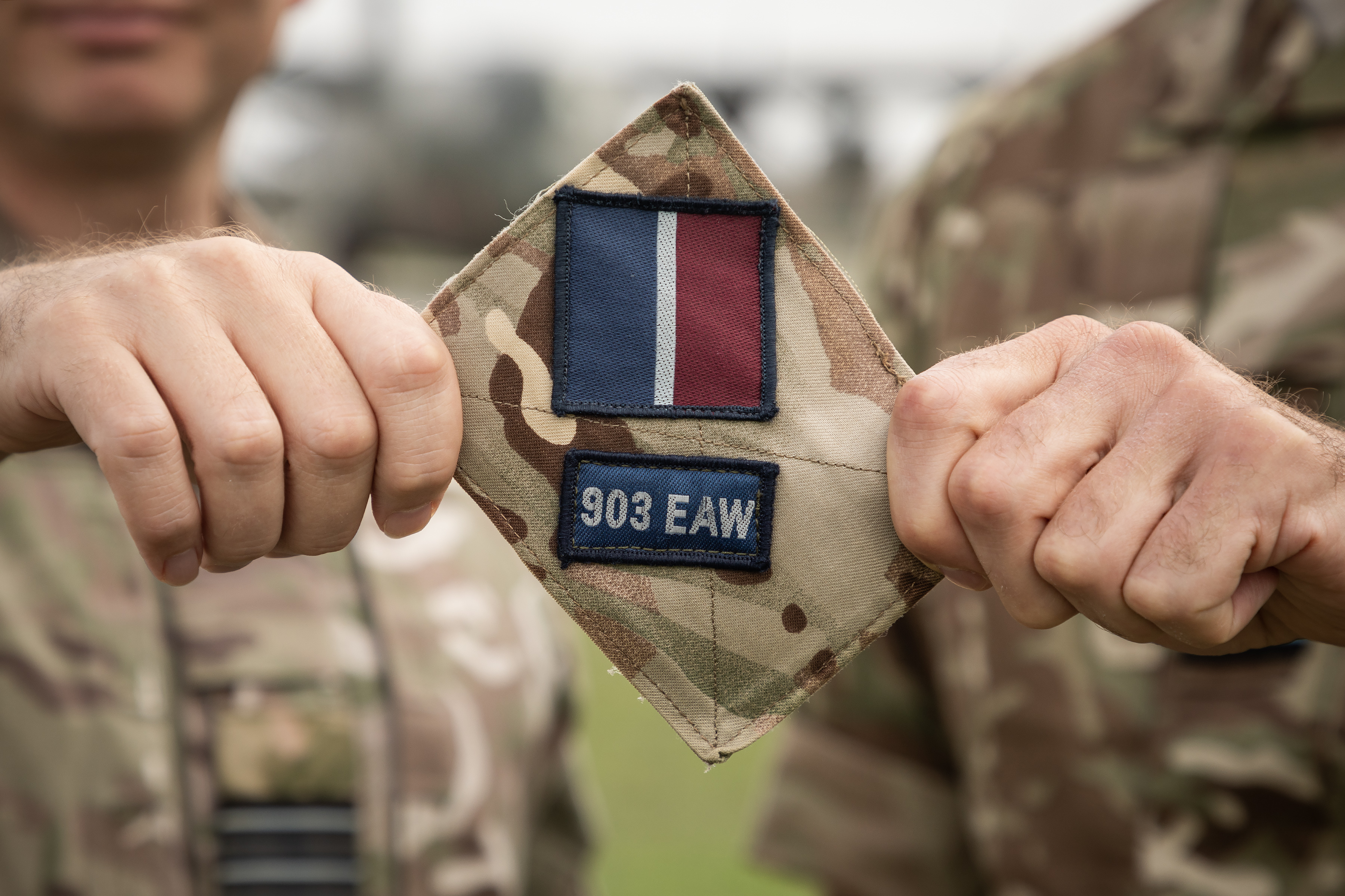 Image shows a close up of RAF aviators holding Expeditionary Air Wing badge.